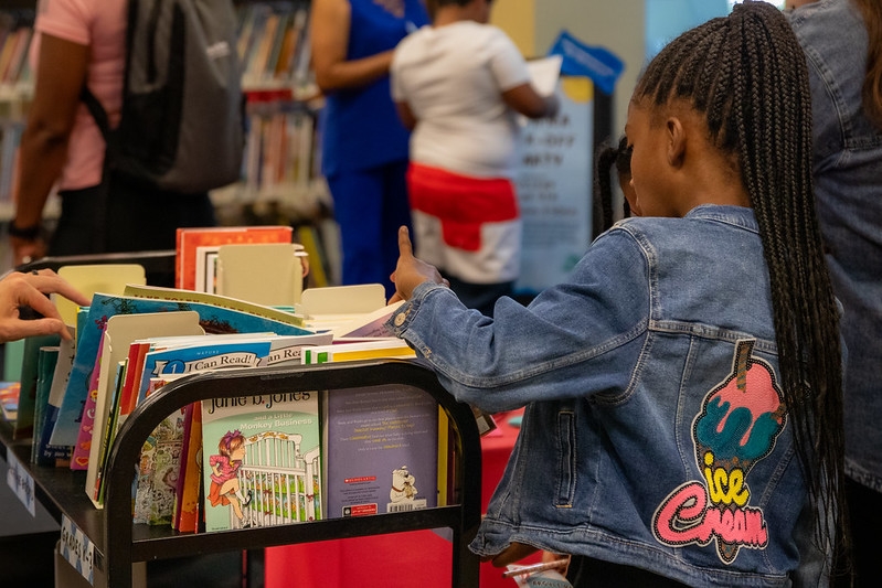 A child picks a free book from a cart