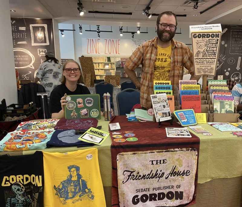 Zine creators pose for a picture behind their table at DCAZ Fest 2023.